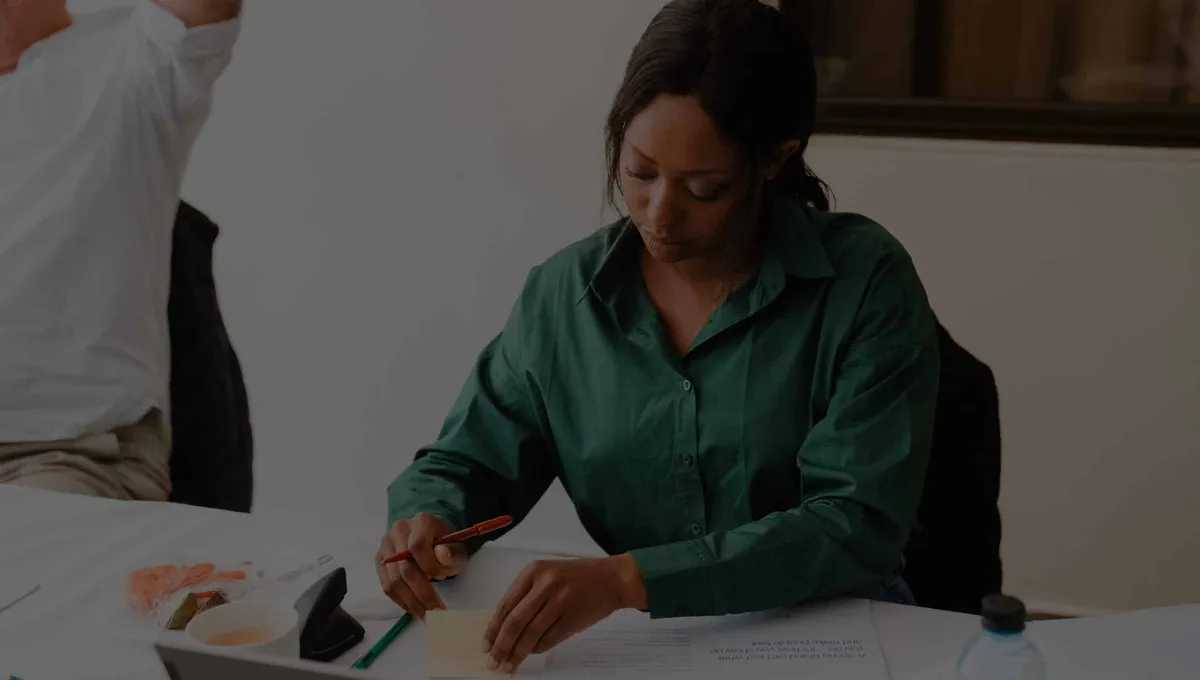 Elewa team member sketching website ideas at a workshop table.