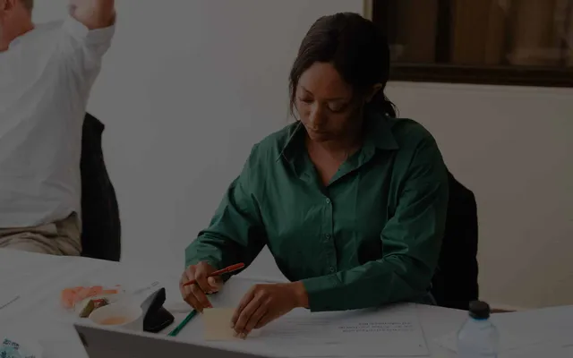 Elewa team member sketching website ideas at a workshop table.